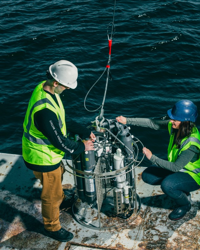 Oceanographers working on a deck with a CTD